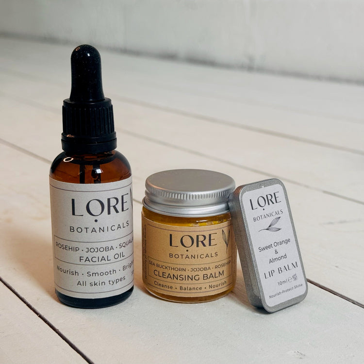 cleansing balm, facial oil and lip balm on a white background