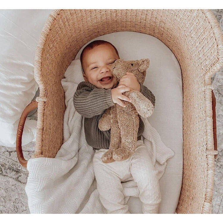 newborn baby holding a snuggly senger-naturwelt toy