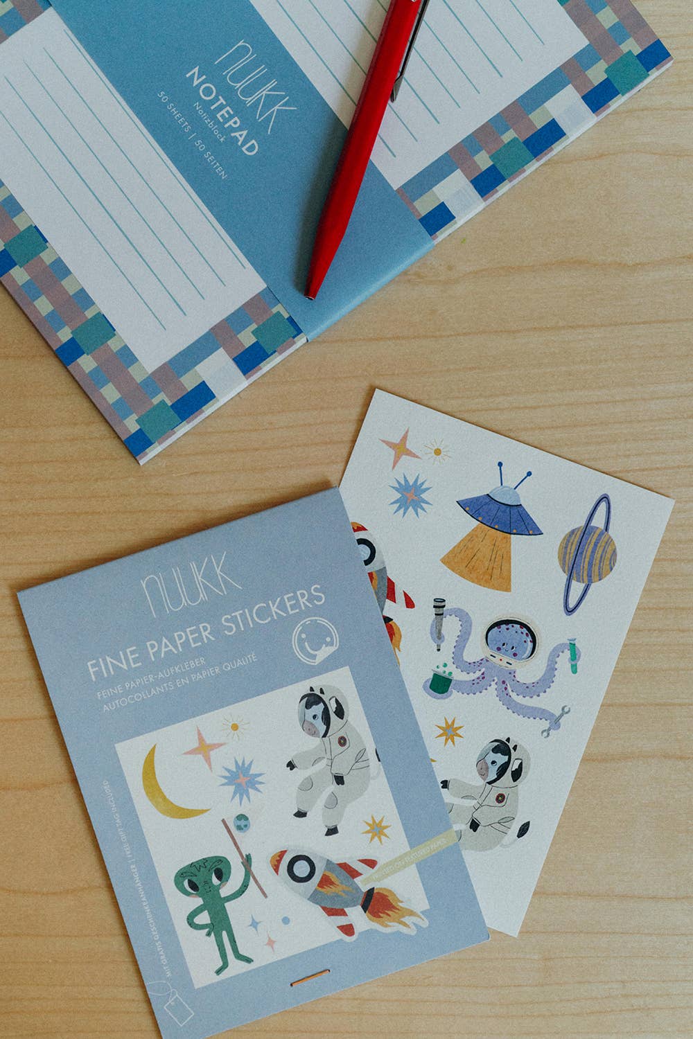 Flikk notebook, stickers, and pen on a wooden surface