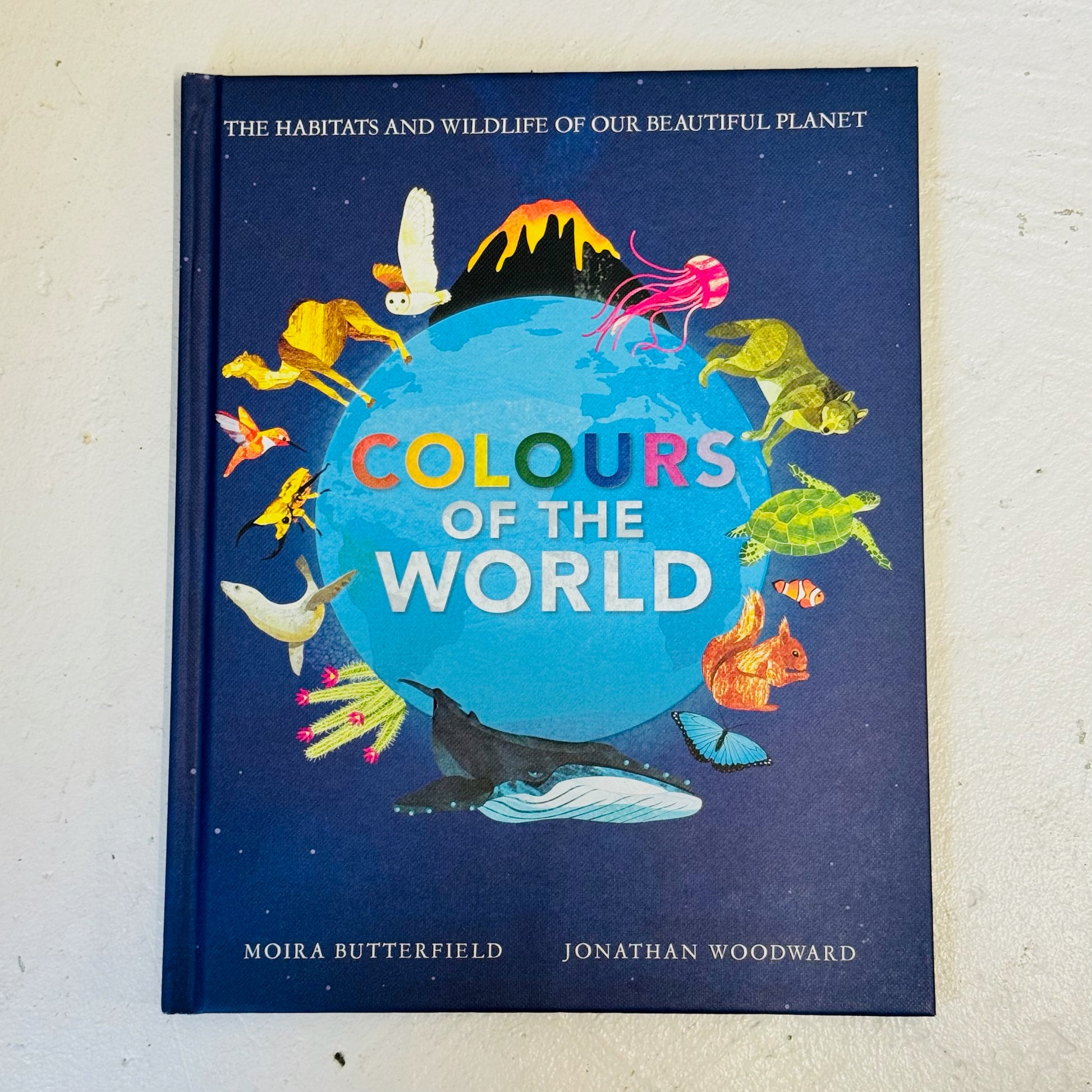 Book titled 'Colours of the World' with illustrations of animals around a globe on a blue background.