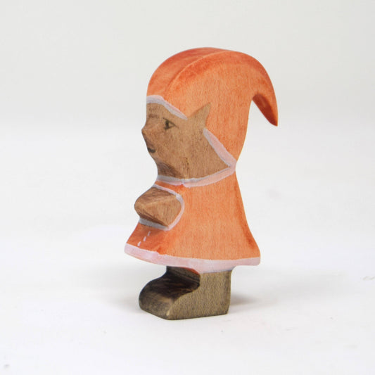 Wooden figurine of an elf wearing an orange hooded cloak on a white background