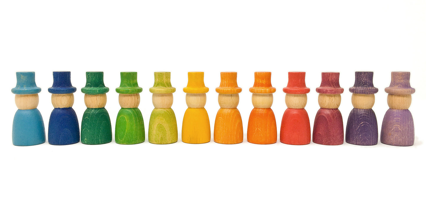 A series of 12 colorful wizard-shaped toys made of wood, displayed in a rainbow order.