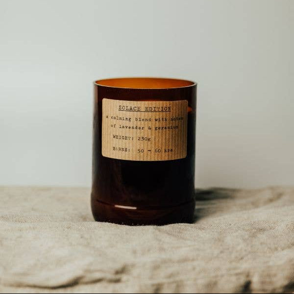 Candle with a label on a textured surface and light background