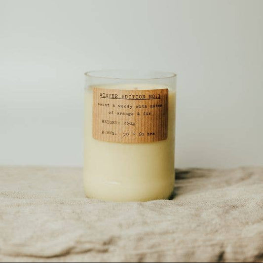 Candle with a wooden label on a textured surface